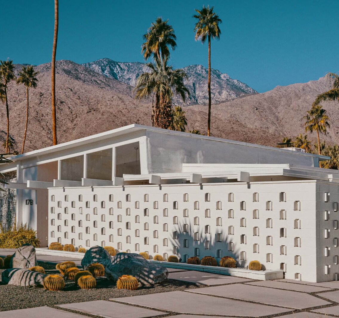 A white suburban architect house with a driveway and a garage.