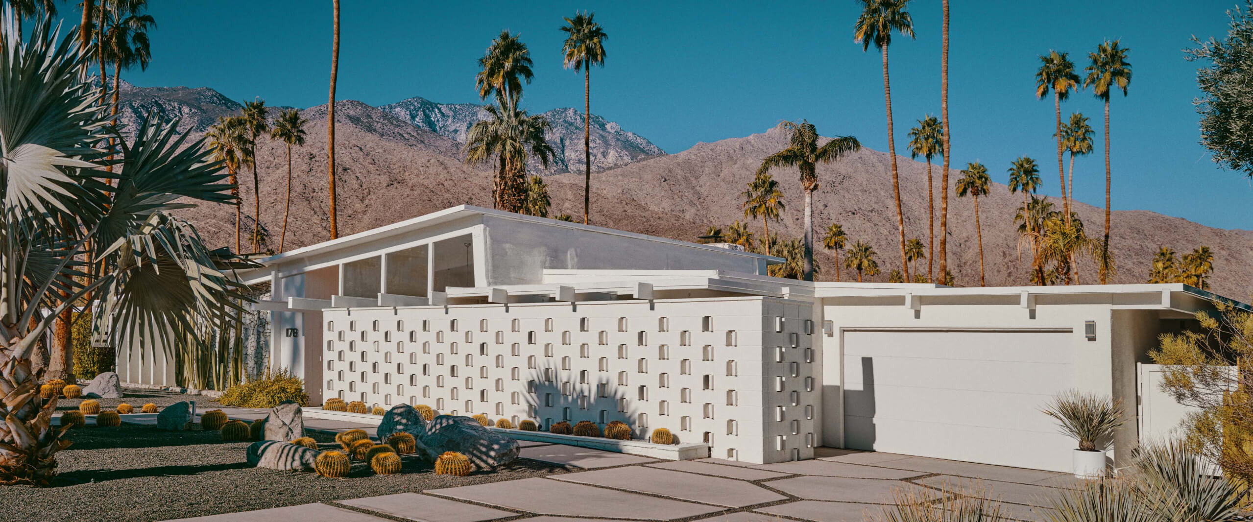 Electromobility and innovations from Mercedes-Benz A white suburban architect house with a driveway and a garage.