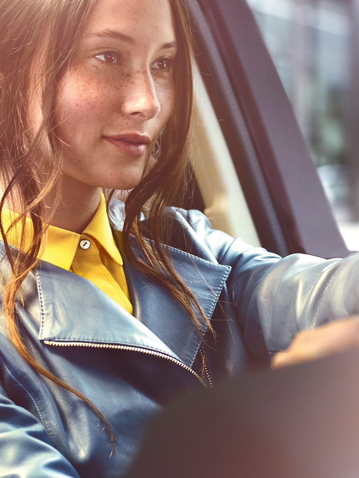 A relaxed man is sitting in front of his Mercedes with his tablet.