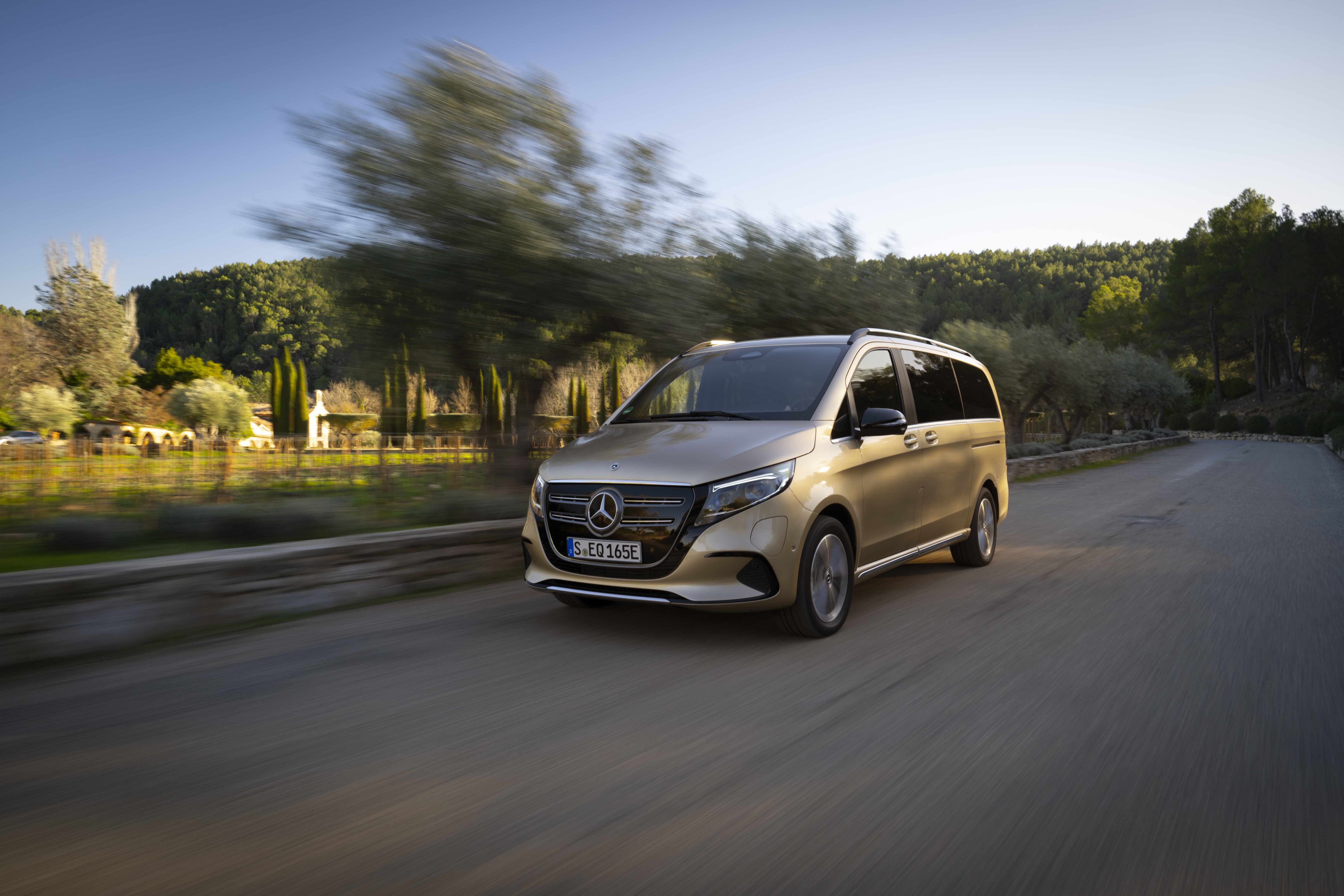 EQV | Mercedes-Benz The image shows the Mercedes-Benz EQV driving on a road.