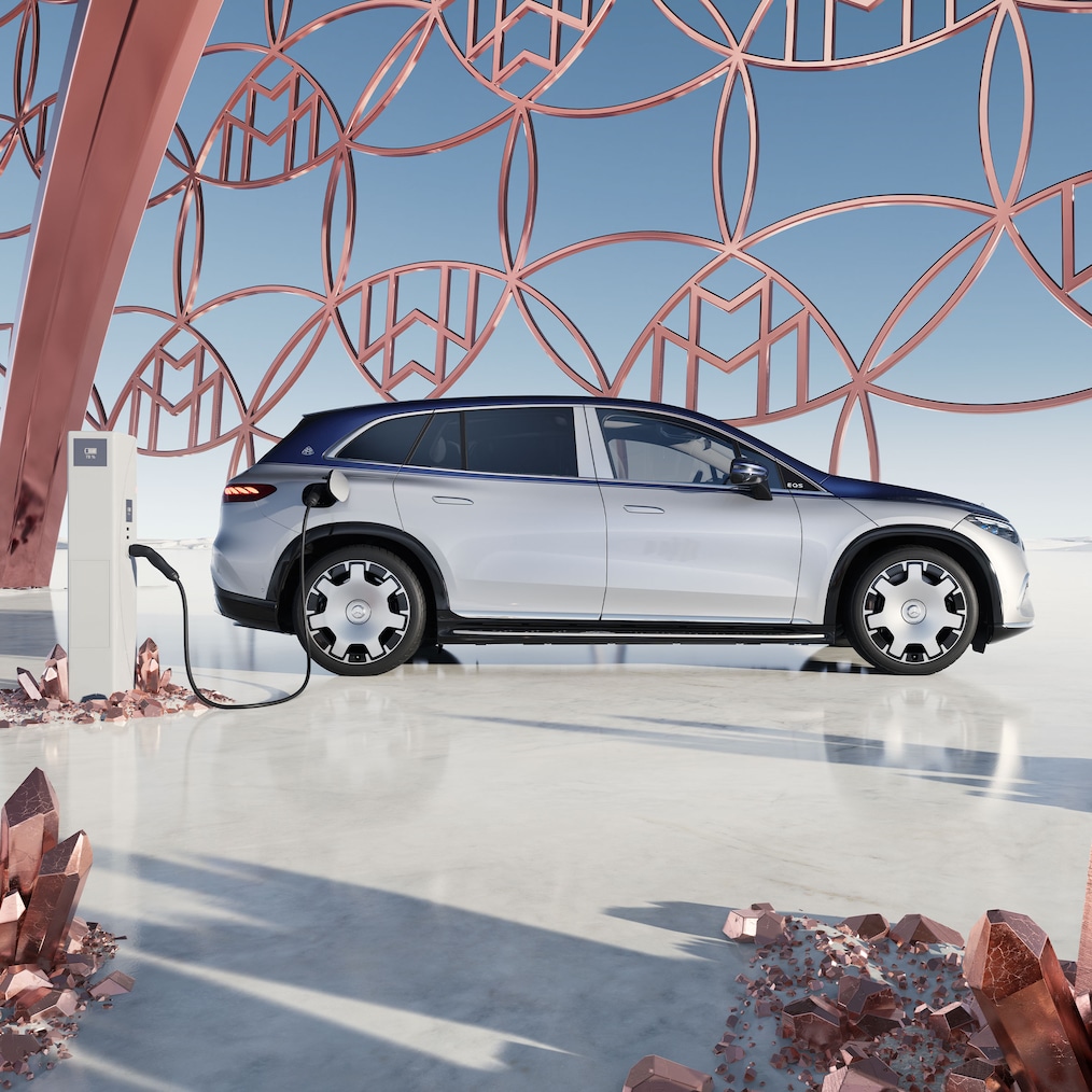Side view of the Mercedes-Maybach EQS SUV at the charging station, with the Maybach brand logo in the background.