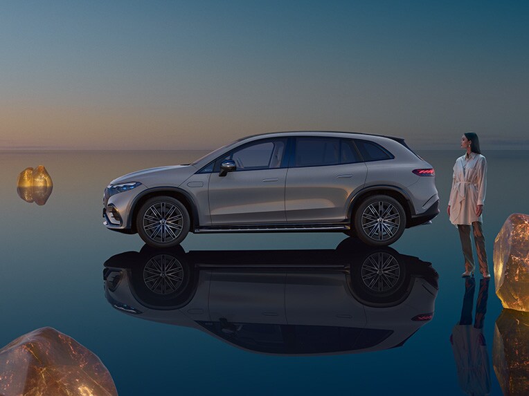 The all-electric EQS SUV from Mercedes-EQ standing in its EQS SUV world with a mirroring floor surface.