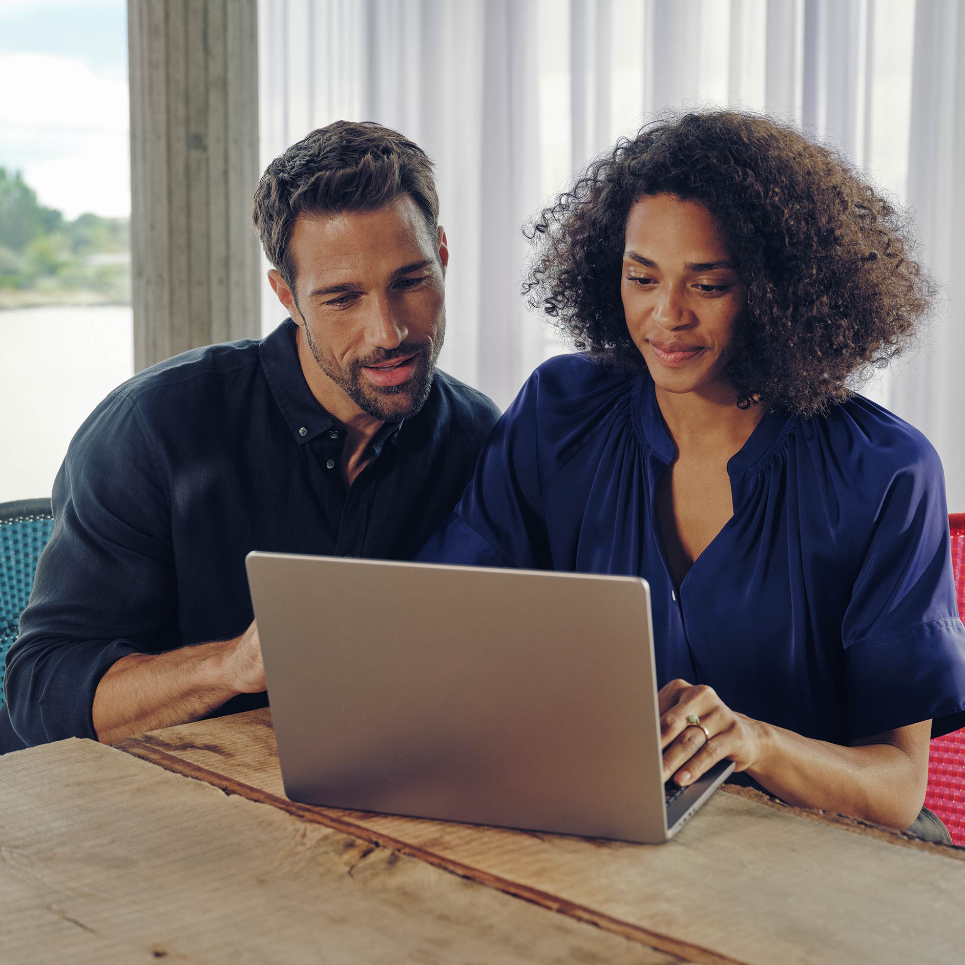 Rent | Financial Services | Mercedes-Benz Man and woman seated at a desk looking at a laptop