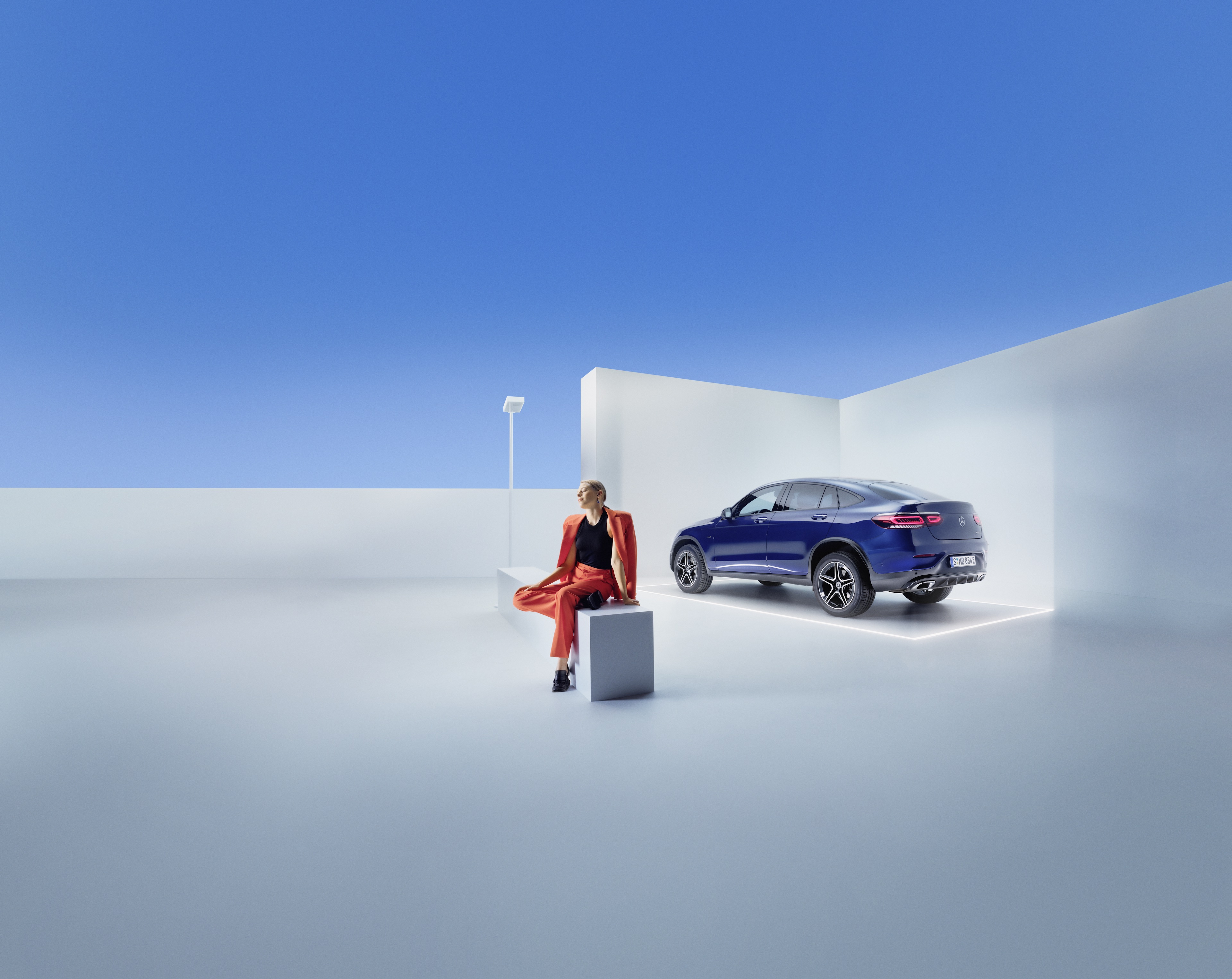 Service Contracts | Mercedes-Benz A woman sits on a bench in front of a Mercedes-Benz.