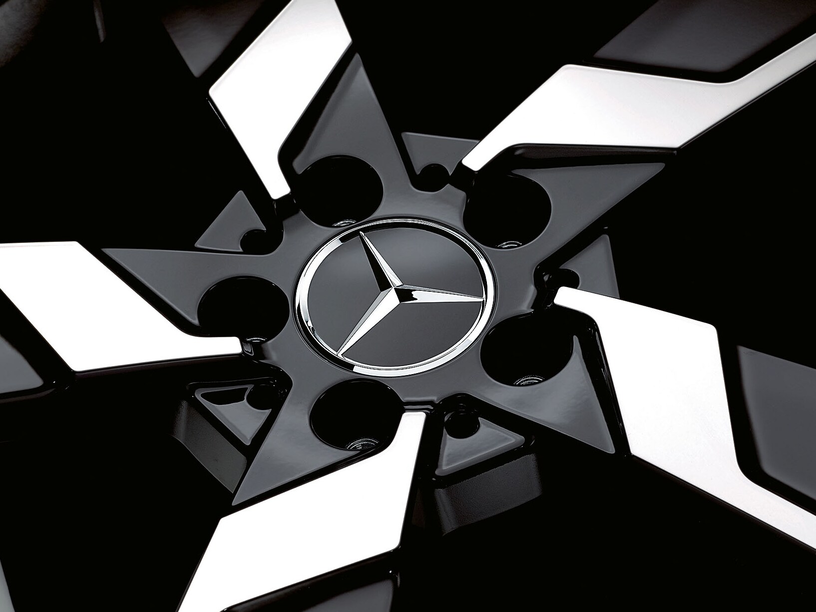 The close-up shows a black and silver Mercedes-Benz rim.