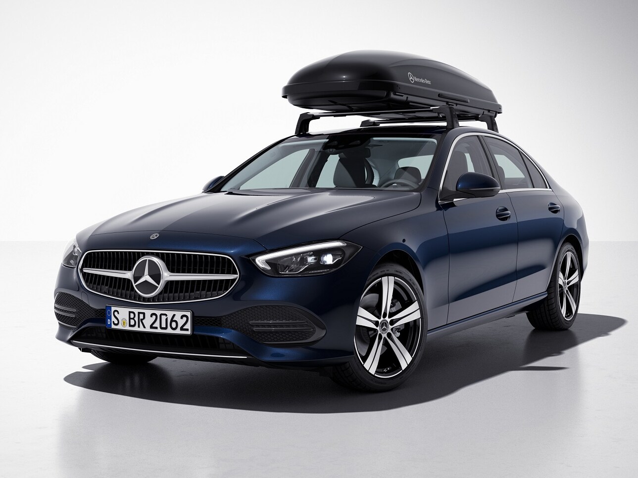 A black Mercedes-AMG roof box mounted on the roof of a blue Mercedes-Benz vehicle.