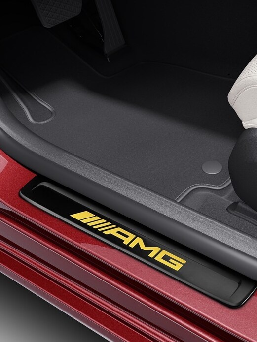 A red Mercedes-Benz fitted with an AMG interchangeable cover with yellow lettering.