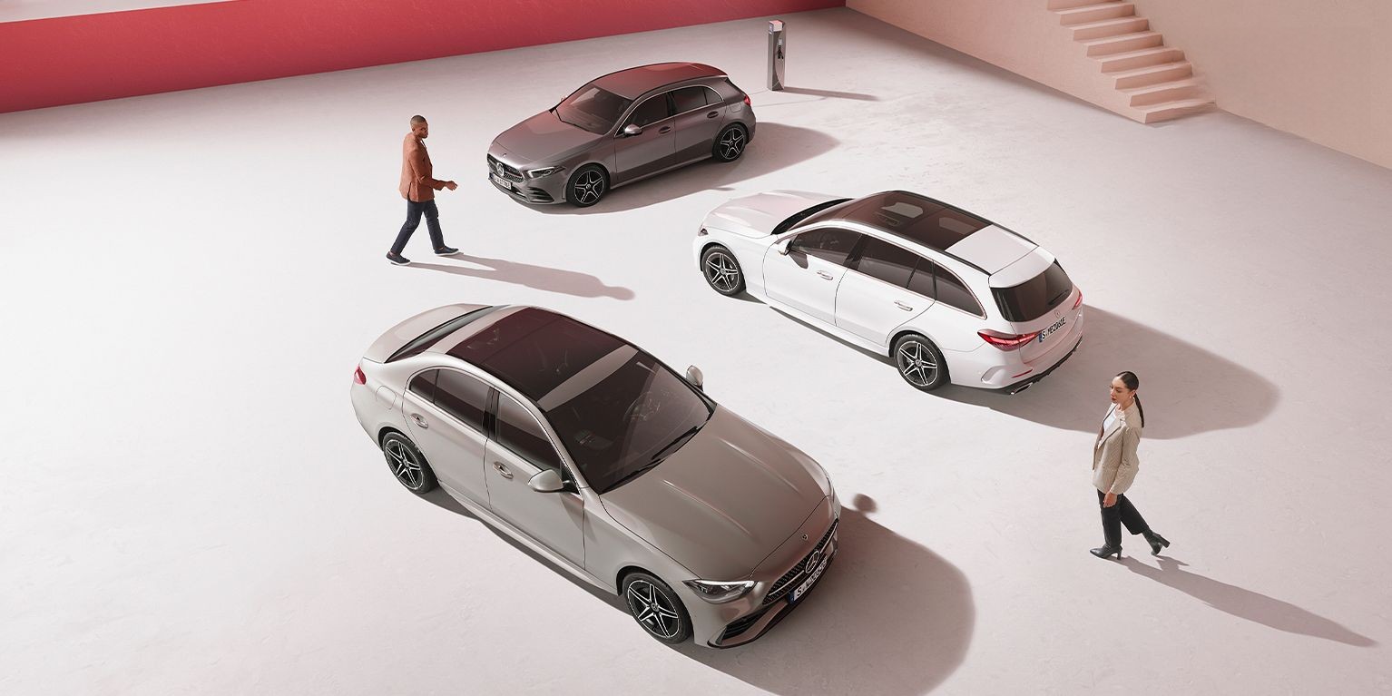 Mercedes-Benz charging solutions for business customers A man and woman in between different passenger car models from Mercedes-Benz
