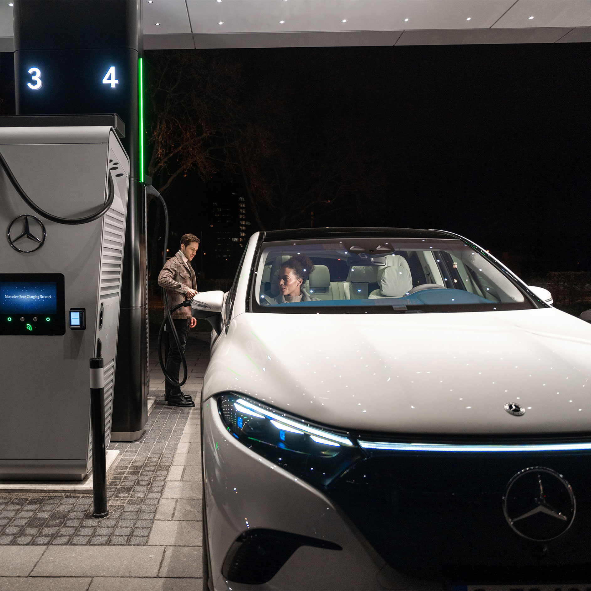 Charging solutions | Technology | Mercedes-Benz The Mercedes-Benz CLA standing on a street, connected to a charging station.