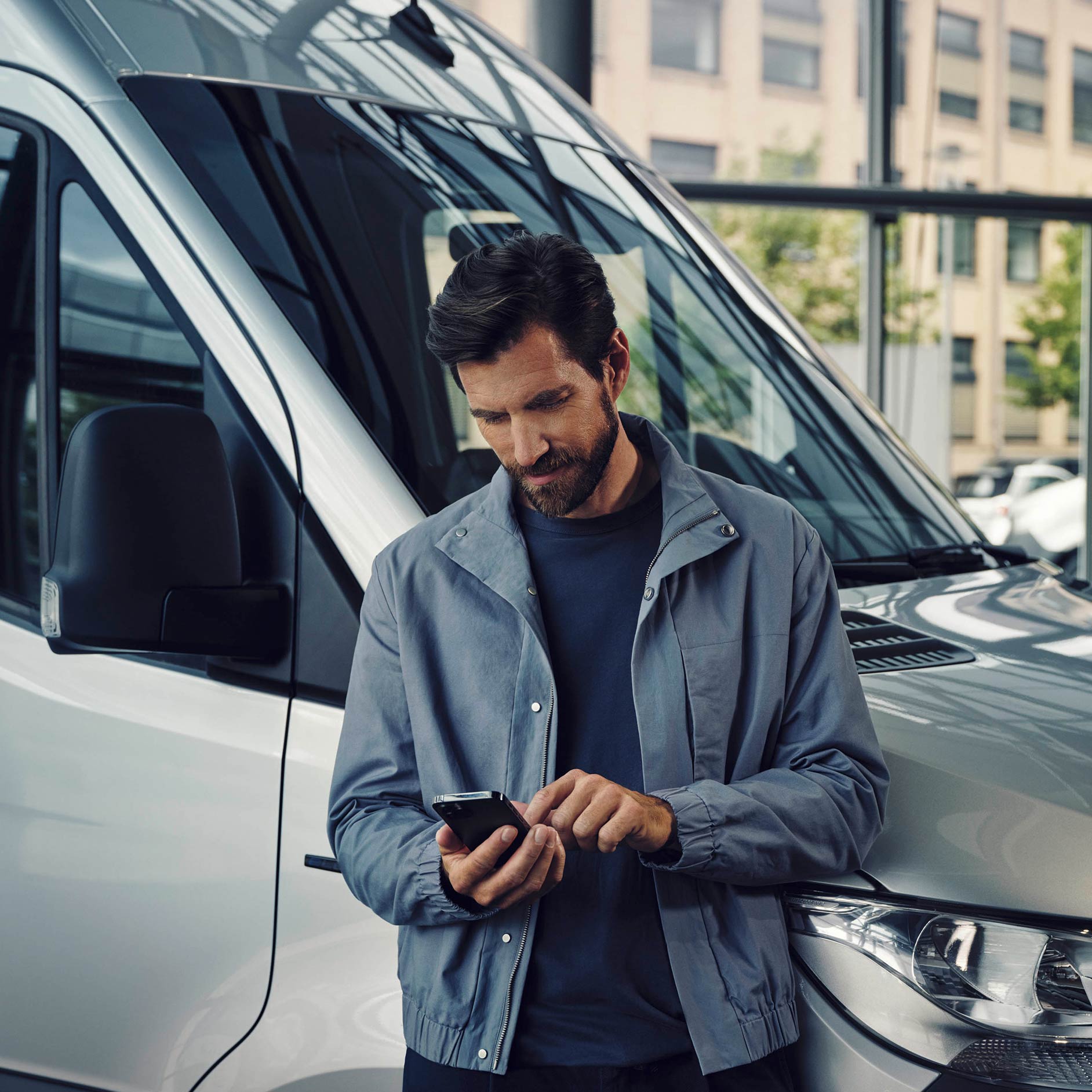 Subscription | Financial Services | Mercedes-Benz Vans A man standing next to a white Mercedes-Benz eSprinter Van talking on the phone