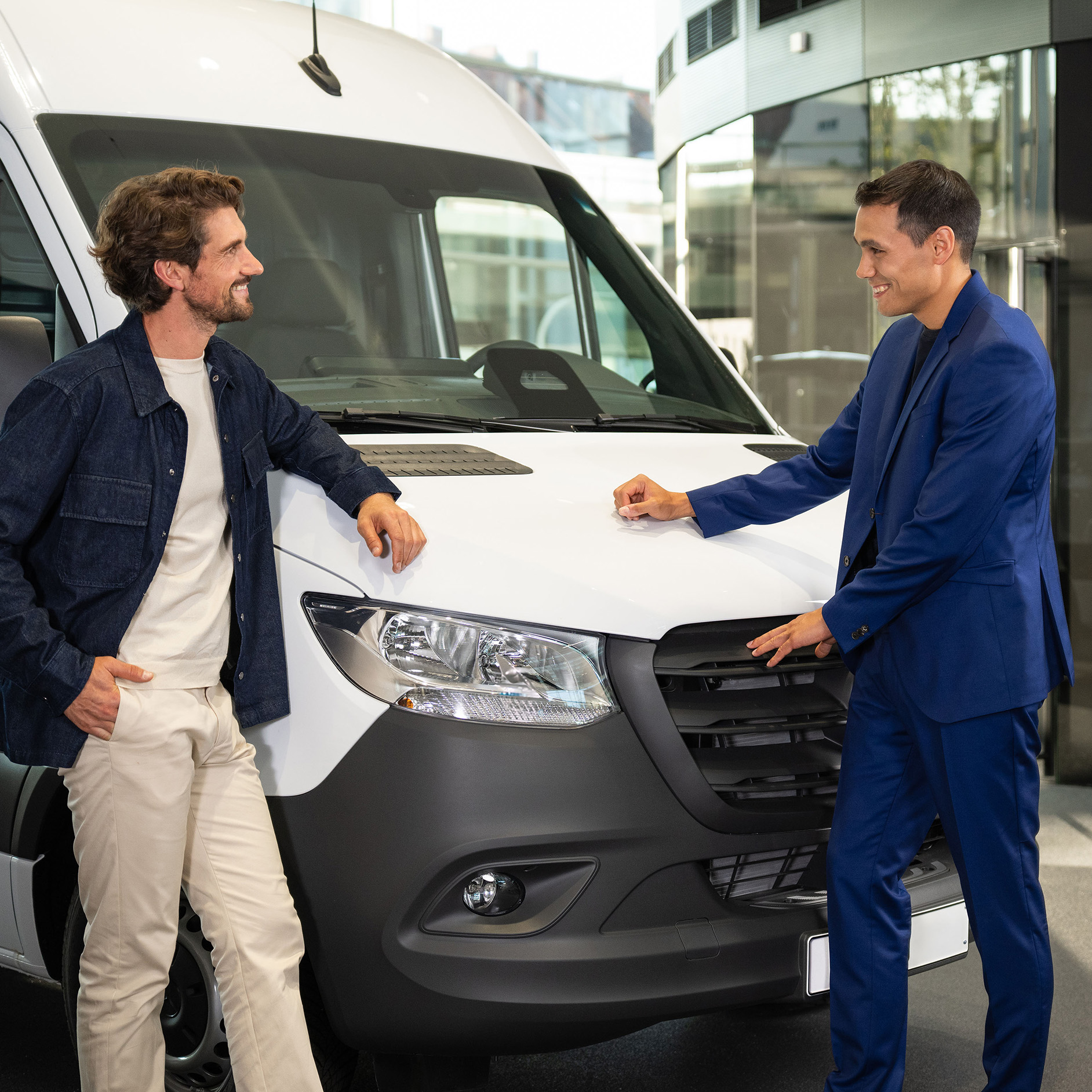 Finance offer for your Mercedes-Benz Two people leaning against a Mercedes-Benz van and having a conversation.