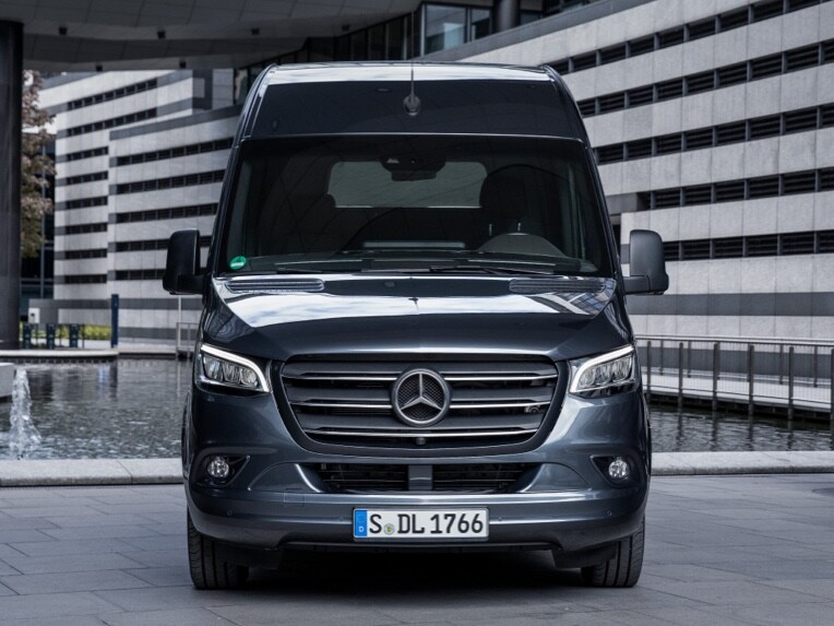 A front view of a Mercedes-Benz Sprinter Panel Van parked in an urban environment.